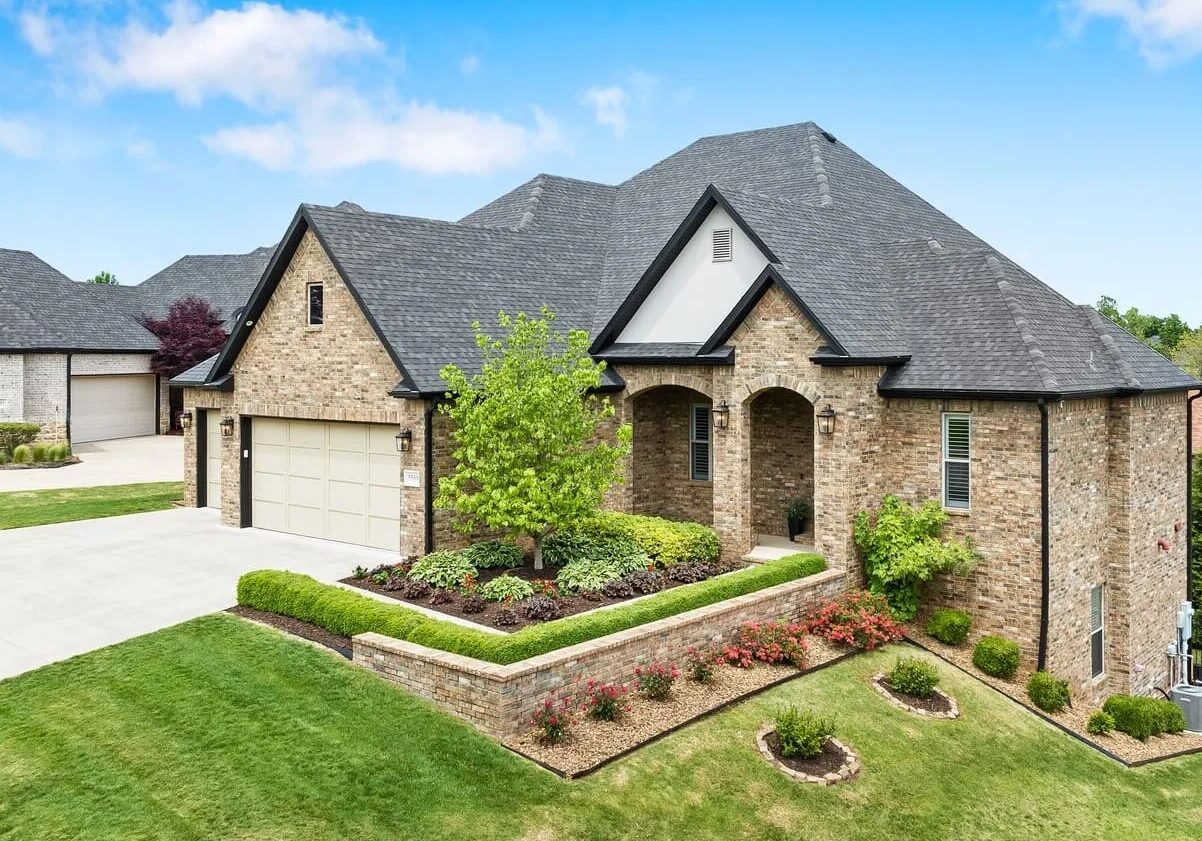 A large brick house with a lot of green grass.